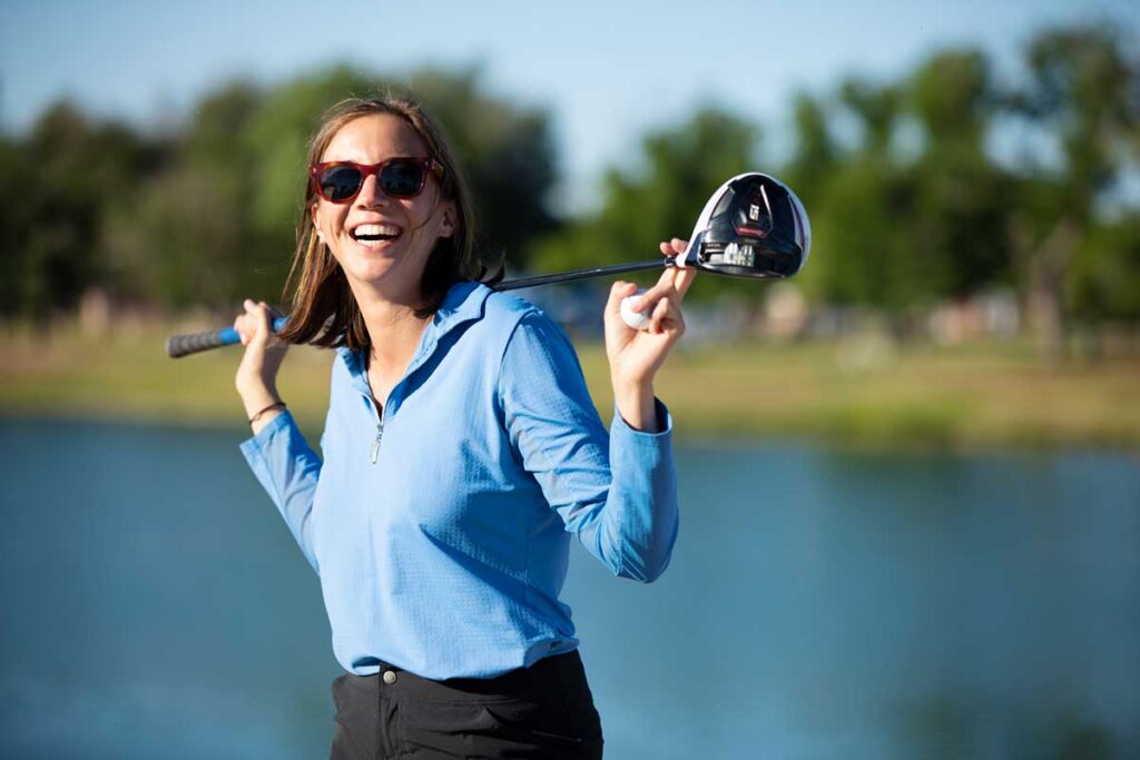 Woman golfer in front of water. Golfing is one of the many things you can enjoy in Carlsbad, New Mexico.