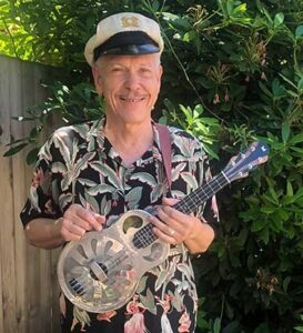Casey MacGill holdling a resonator ukulele.