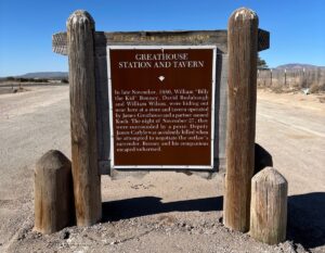 Greathouse Station and Tavern historical marker in New Mexico with a bright blue sky and distant mountains.