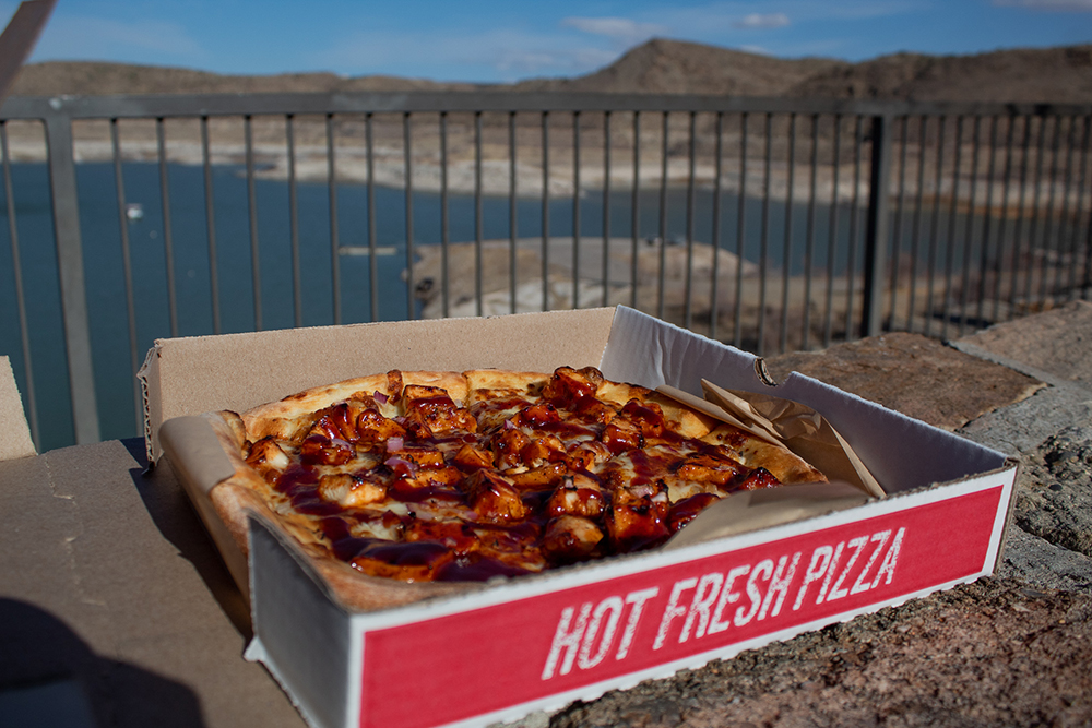 BBQ Chicken pizza in a to go box over looking Elephant Butte