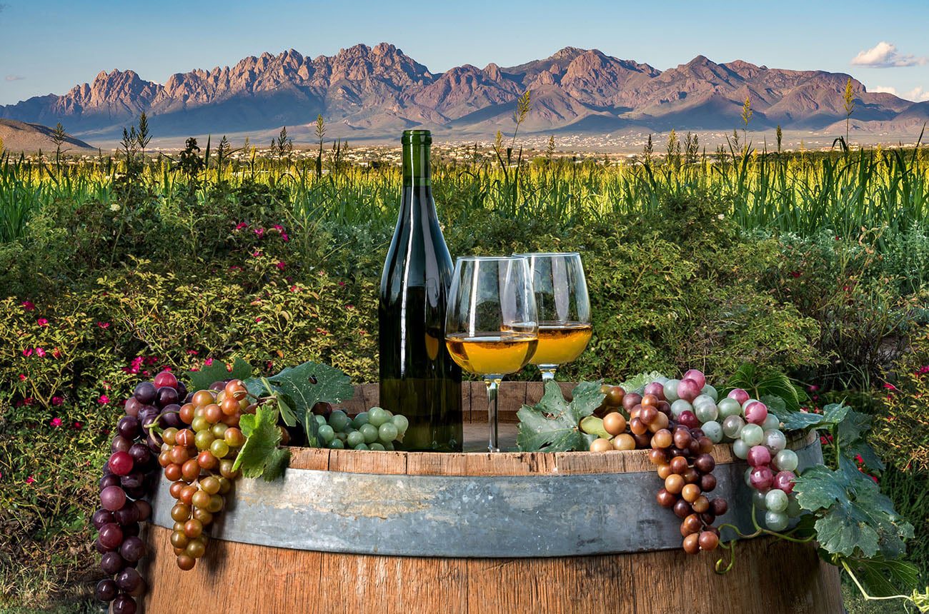 Wine bottle and glasses on a barrel with Organ Mountains in the background