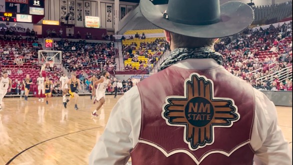 The NMSU emblem on the back of Pistol Pete's leather vest at a NMSU basketball game.