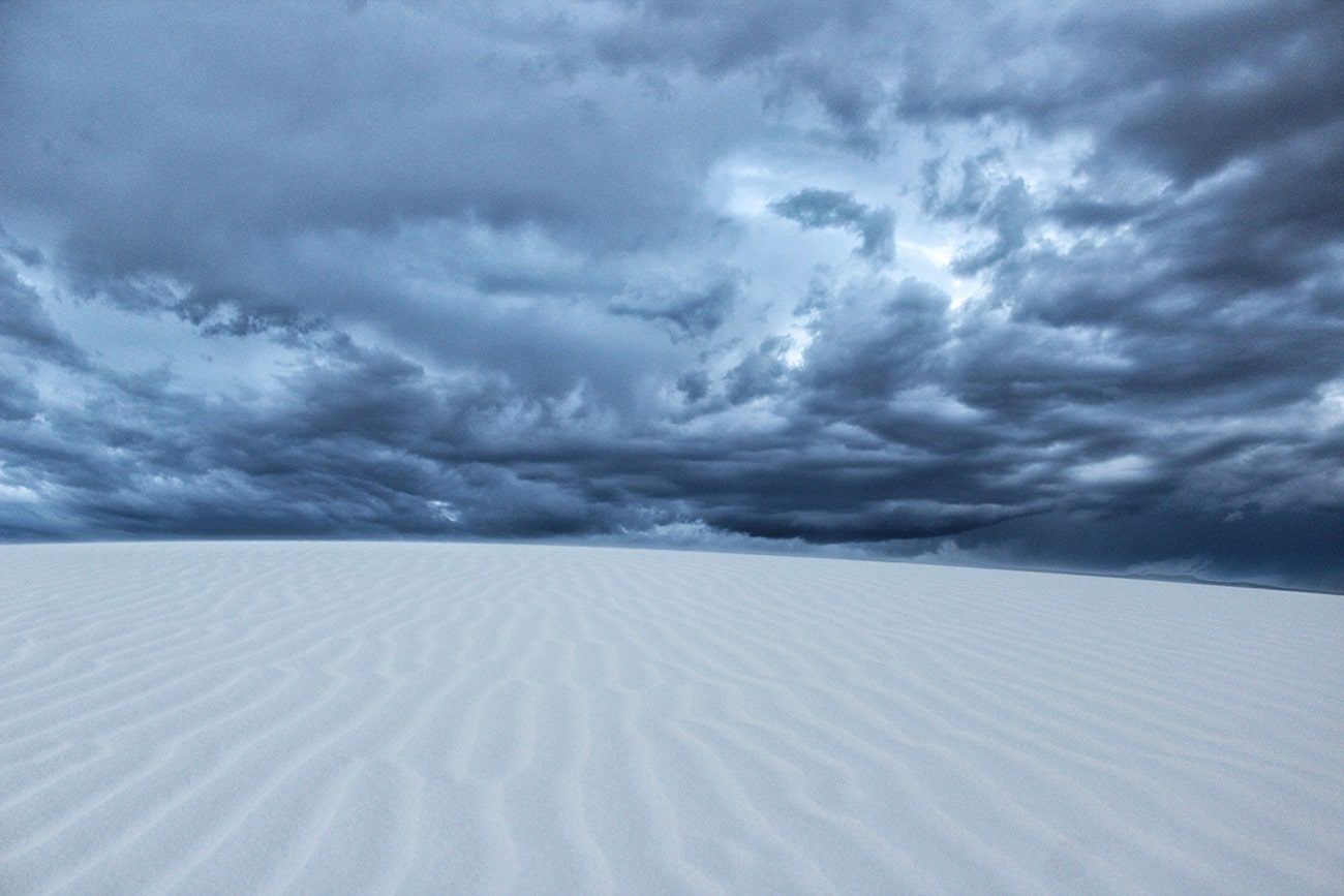 White Sands National Park with gypsum sand dunes under a cloudy sky.