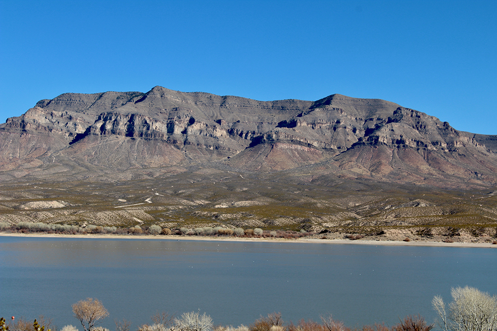 Caballo Lake and the Caballo Mountains under a clear blue sky midday.