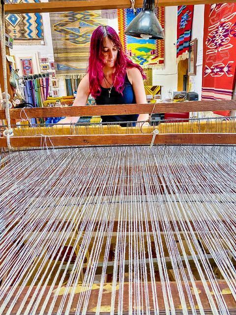 Emily Trujillo puts a contemporary spin on Chimayo weaving at her famous family’s atelier and store. The photo from the book "Slow Travel New Mexico" shows her weaving at a loom.