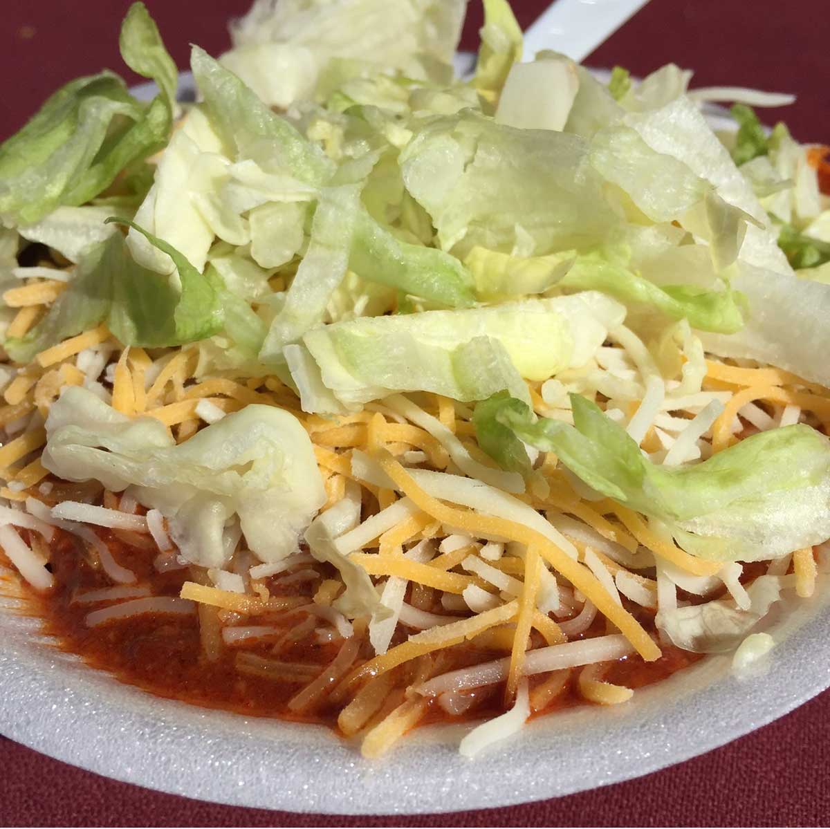 Frito Pie with lettuce and cheese.