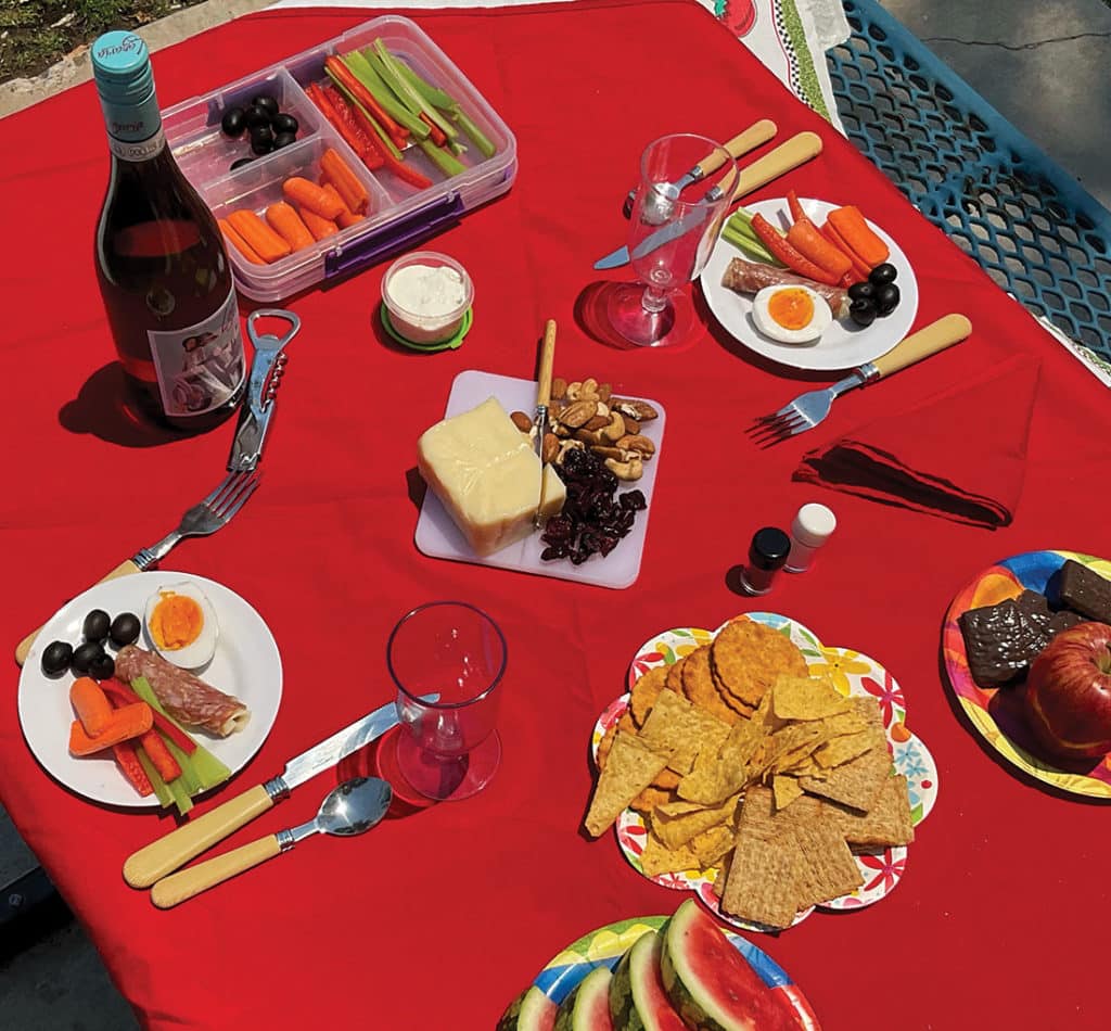 Picnic foods on a red tablecloth.
