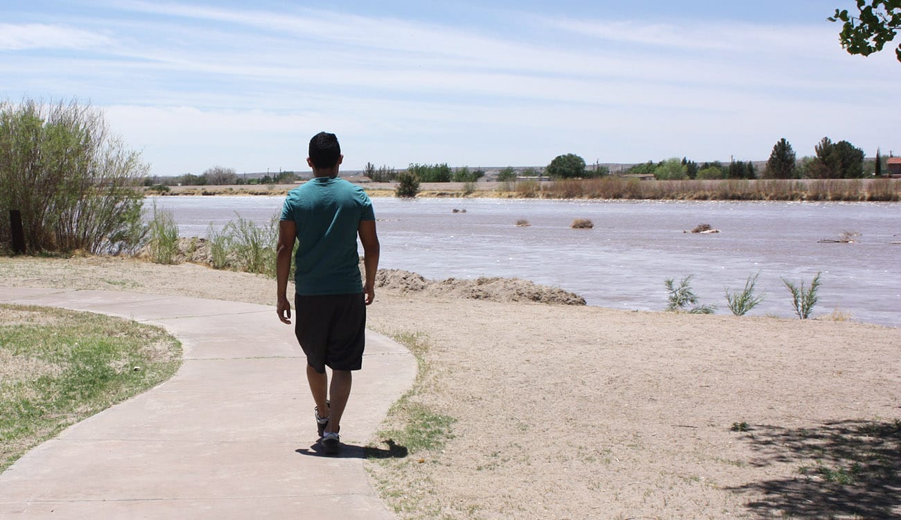 Man walking on trail at La Llorona Park in Las Cruces, New Mexico.
