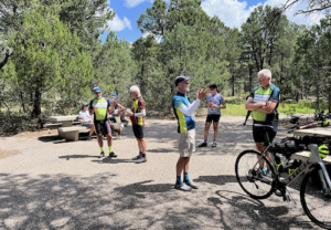New Mexico Touring Society cyclists in uniform gathered talking.
