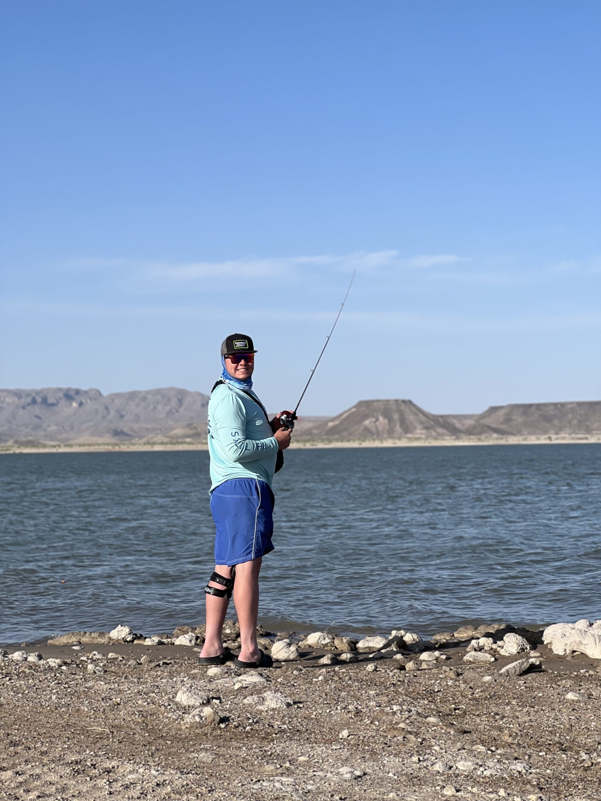 fisherman casting his line shorside with kettle top mountain on elephant butte state park