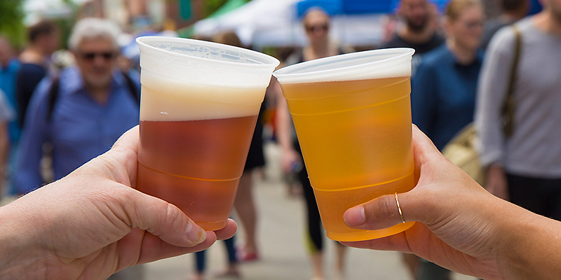 Two people tapping their beers together at the Las Cruces Beer Festival