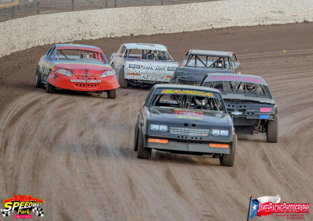 Five cars racing neck and neck at Vado Speedway Park